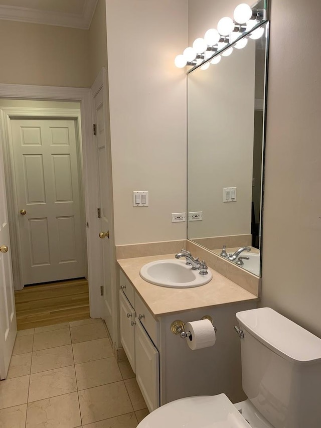 bathroom featuring vanity, ornamental molding, toilet, and tile patterned flooring