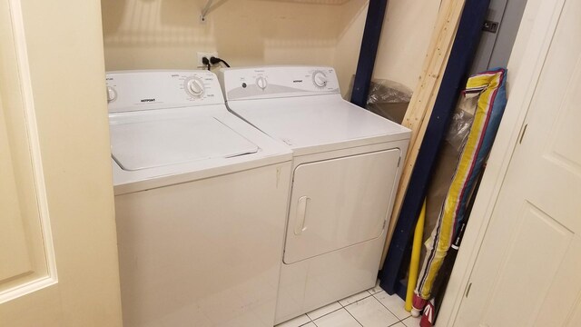 washroom featuring separate washer and dryer, laundry area, and light tile patterned floors