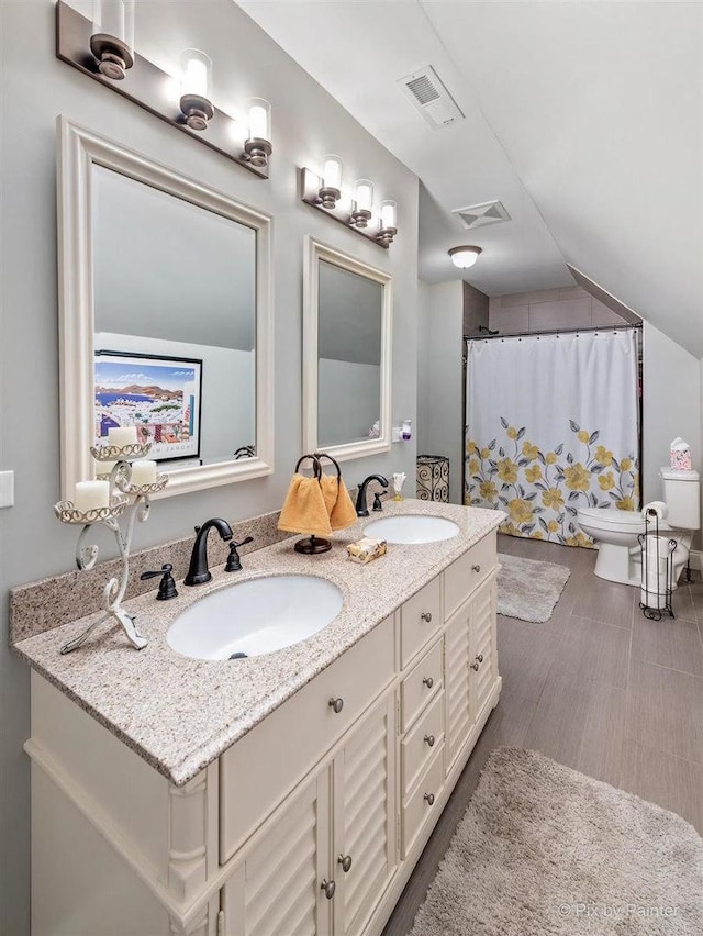 bathroom featuring a sink, toilet, double vanity, and visible vents