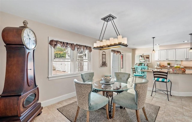 dining space featuring baseboards and light tile patterned flooring