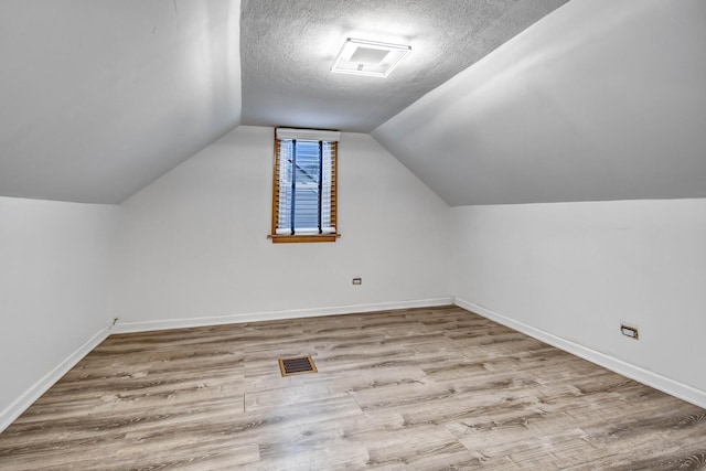 11549 S Kilbourn Ave, Alsip, IL 60803 - bonus room featuring baseboards, lofted ceiling, wood finished floors, and a textured ceiling