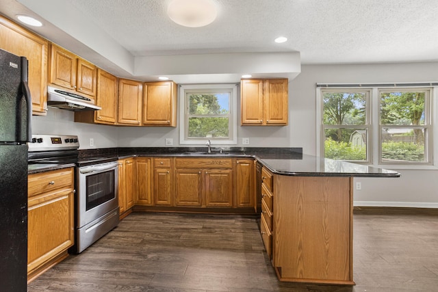 2409 Valkar Ln, Champaign, IL 61822 - kitchen with stainless steel electric range, under cabinet range hood, a peninsula, freestanding refrigerator, and a textured ceiling