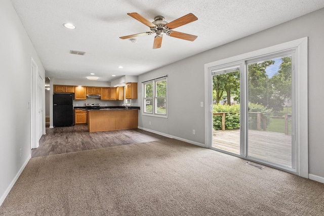2409 Valkar Ln, Champaign, IL 61822 - kitchen with freestanding refrigerator, dark colored carpet, open floor plan, dark countertops, and baseboards