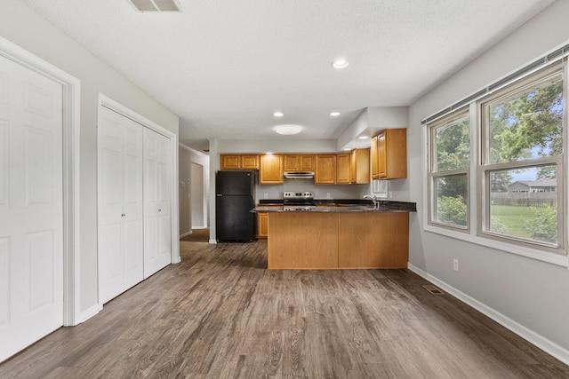 2409 Valkar Ln, Champaign, IL 61822 - kitchen with freestanding refrigerator, dark countertops, dark wood-style floors, a peninsula, and recessed lighting