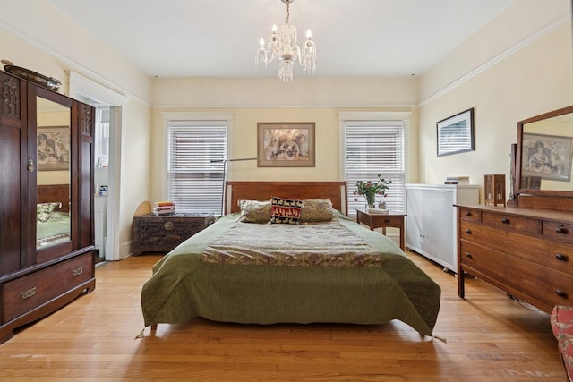 bedroom featuring light wood-style flooring and a chandelier