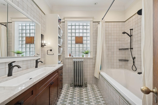 bathroom with radiator heating unit, plenty of natural light, tile walls, and crown molding