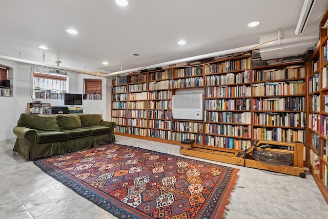 living area featuring recessed lighting and bookshelves