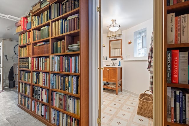 sitting room with wall of books and light floors