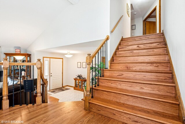 681 Vanderbilt Dr, New Lenox, IL 60451 - stairway featuring baseboards, wood finished floors, and high vaulted ceiling