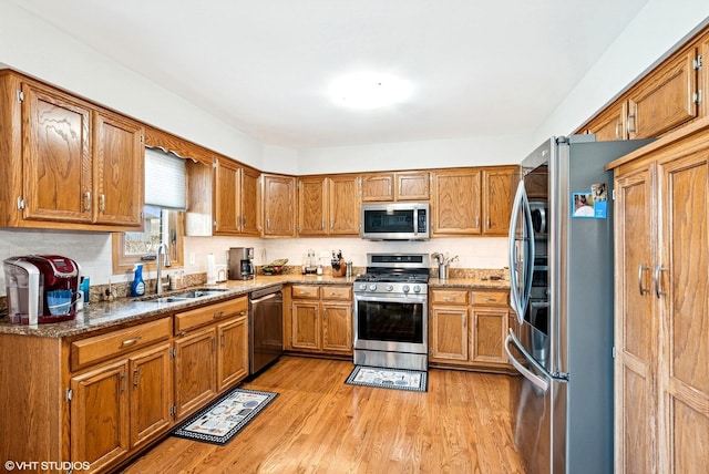 681 Vanderbilt Dr, New Lenox, IL 60451 - kitchen with a sink, stone countertops, brown cabinetry, stainless steel appliances, and light wood-type flooring