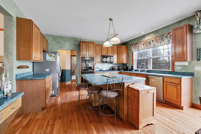 1581 Hunting Hound Ln, Bartlett, IL 60103 - kitchen featuring a breakfast bar, black appliances, a kitchen island, and light wood finished floors
