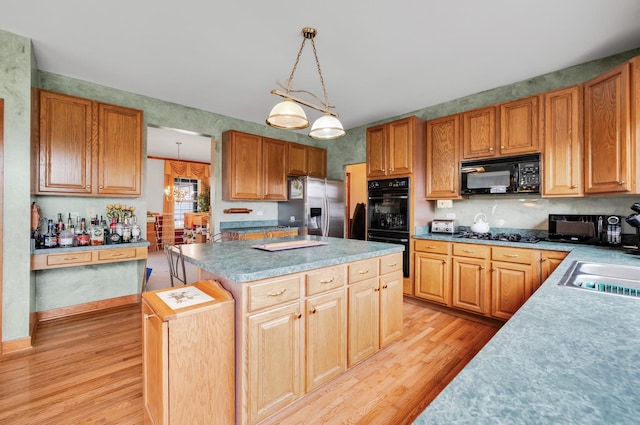 1581 Hunting Hound Ln, Bartlett, IL 60103 - kitchen featuring decorative light fixtures, light wood-style floors, black appliances, and a kitchen island