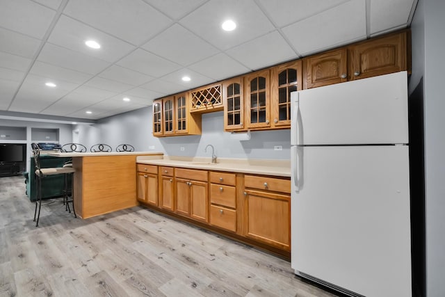1581 Hunting Hound Ln, Bartlett, IL 60103 - kitchen featuring light wood-style flooring, light countertops, freestanding refrigerator, glass insert cabinets, and a sink