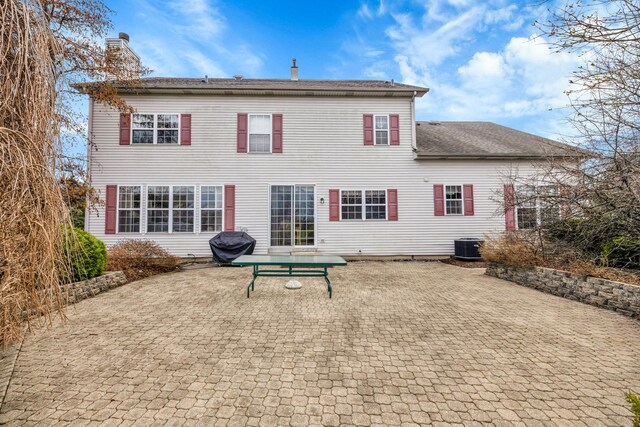 1581 Hunting Hound Ln, Bartlett, IL 60103 - back of property with central air condition unit, a patio, a chimney, and a shingled roof
