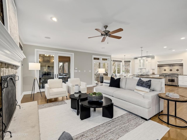 4716 Wallbank Ave, Downers Grove, IL 60515 - living room featuring baseboards, a stone fireplace, crown molding, ceiling fan, and light wood finished floors