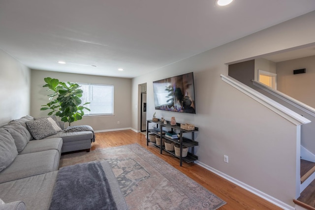 living room featuring wood finished floors, baseboards, and recessed lighting
