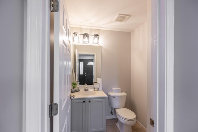 bathroom featuring vanity, baseboards, tile patterned floors, toilet, and visible vents