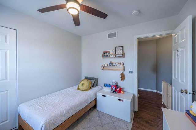 bedroom featuring visible vents, baseboards, a ceiling fan, and wood finished floors