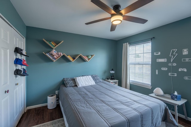 bedroom with wood finished floors, ceiling fan, baseboards, and a closet