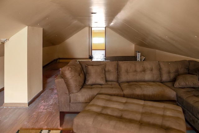 living area featuring baseboards, vaulted ceiling, and wood finished floors