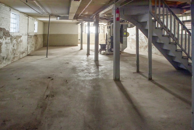 basement with stairs and heating unit