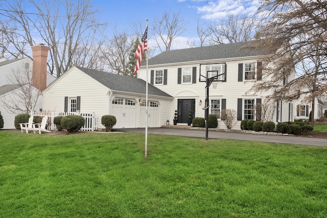 view of front of property with roof with shingles, driveway, an attached garage, and a front lawn
