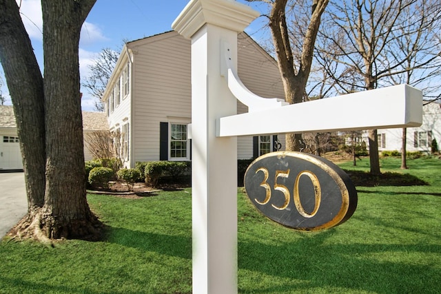 community sign with a lawn and concrete driveway
