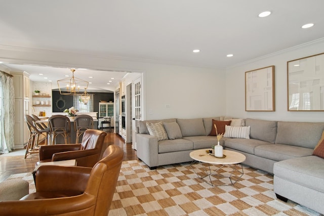 living room with french doors, a notable chandelier, ornamental molding, and recessed lighting