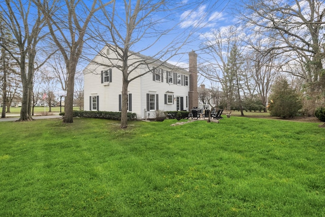view of home's exterior with a yard and a chimney