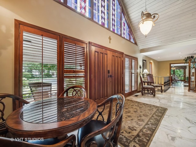 dining space with wood ceiling, high vaulted ceiling, and marble finish floor