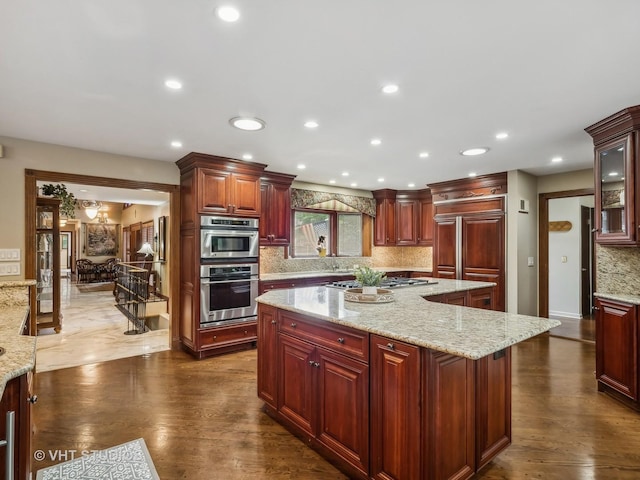 kitchen with dark brown cabinets, backsplash, appliances with stainless steel finishes, and dark wood-style floors