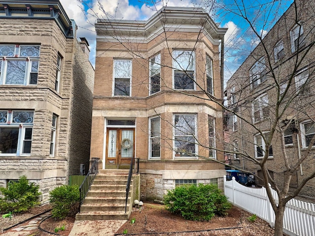 3615 N Janssen Ave, Chicago, IL 60613 - view of front facade featuring stone siding, french doors, and fence