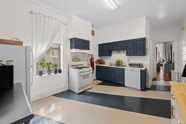 3615 N Janssen Ave, Chicago, IL 60613 - kitchen featuring blue cabinets, white appliances, decorative backsplash, under cabinet range hood, and a sink