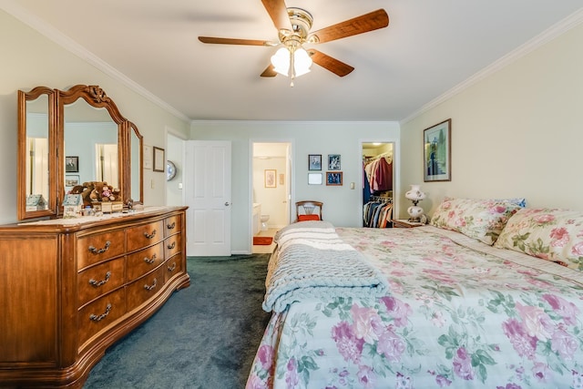 bedroom with crown molding, ceiling fan, dark carpet, ensuite bath, and a walk in closet
