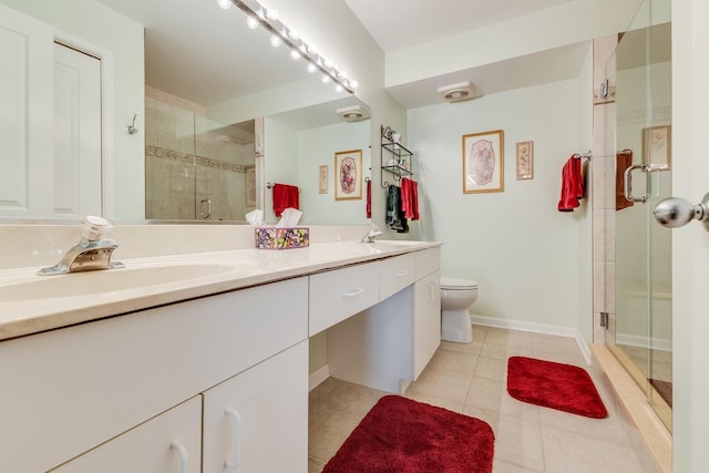 bathroom featuring double vanity, a stall shower, tile patterned flooring, toilet, and a sink