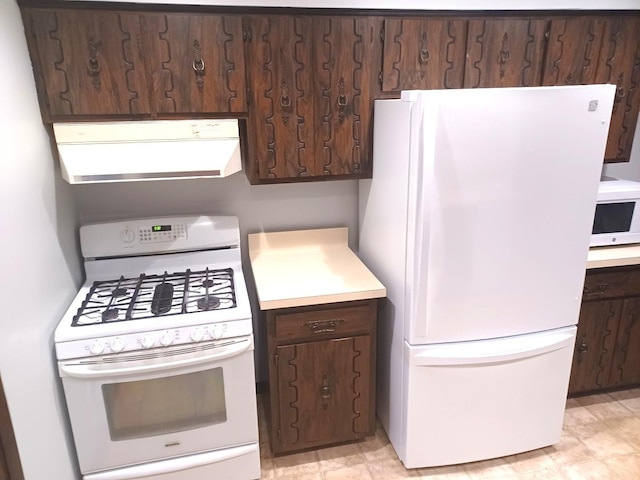 kitchen with light countertops, exhaust hood, white appliances, and dark brown cabinets