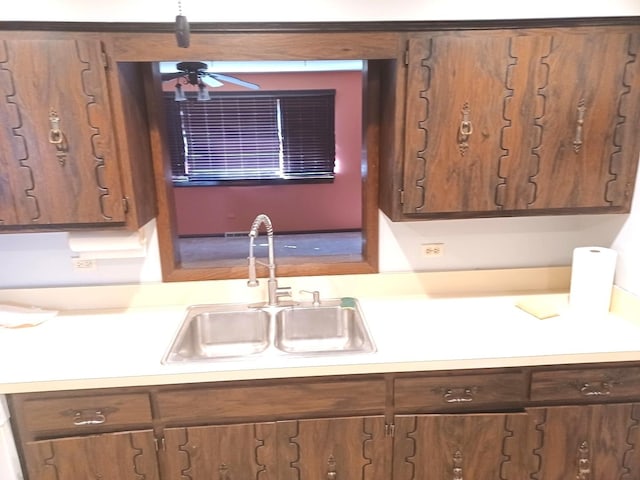 kitchen featuring light countertops, ceiling fan, and a sink
