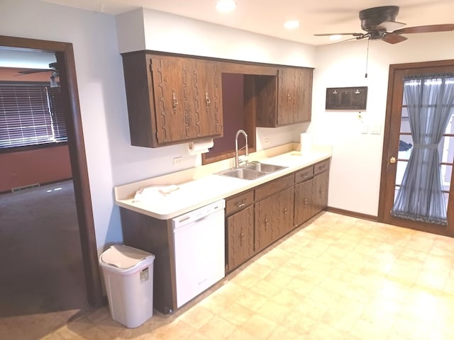 kitchen with white dishwasher, a sink, light countertops, a ceiling fan, and light floors