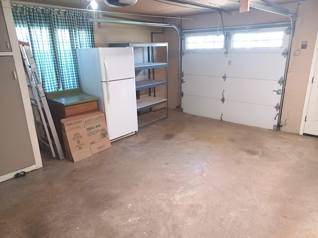 garage with a garage door opener and freestanding refrigerator