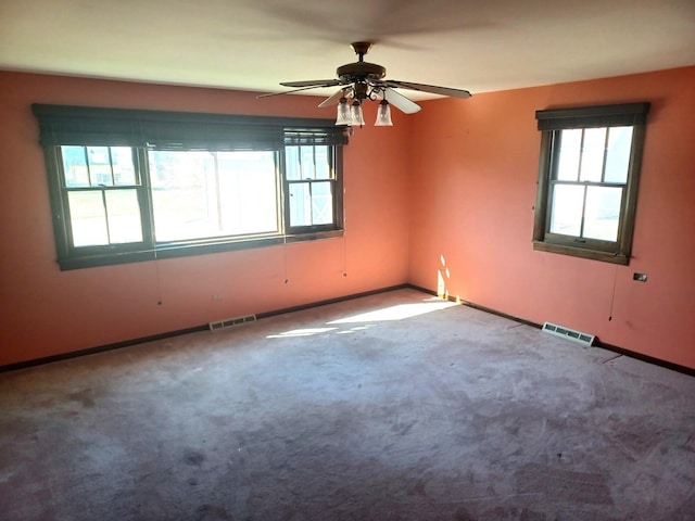 unfurnished room with plenty of natural light, visible vents, and ceiling fan