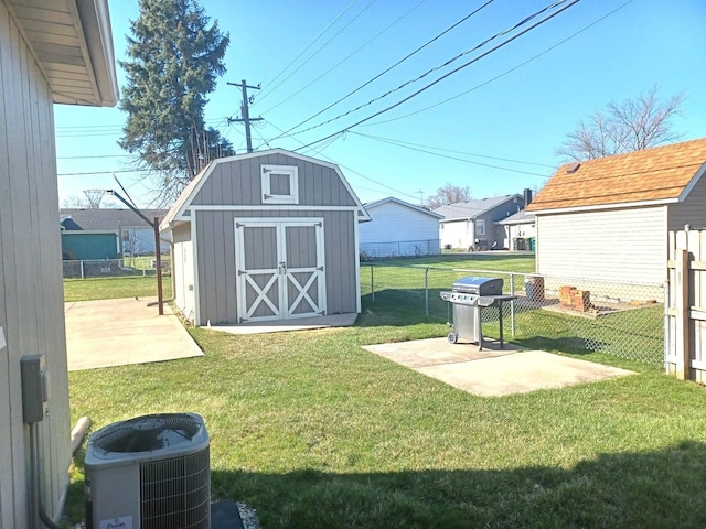 view of yard featuring central AC unit, fence, an outdoor structure, a patio, and a storage unit