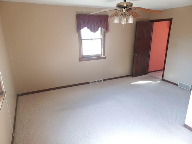 unfurnished room with visible vents, baseboards, and a ceiling fan