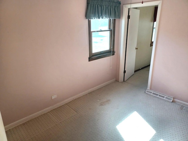 spare room featuring visible vents and baseboards