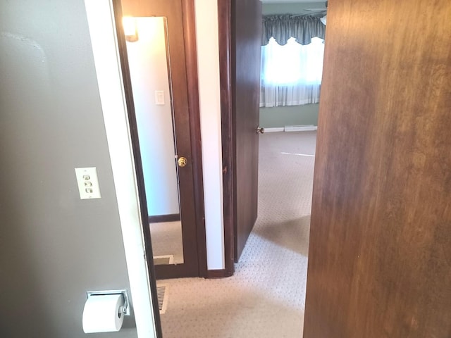 corridor featuring baseboards and carpet