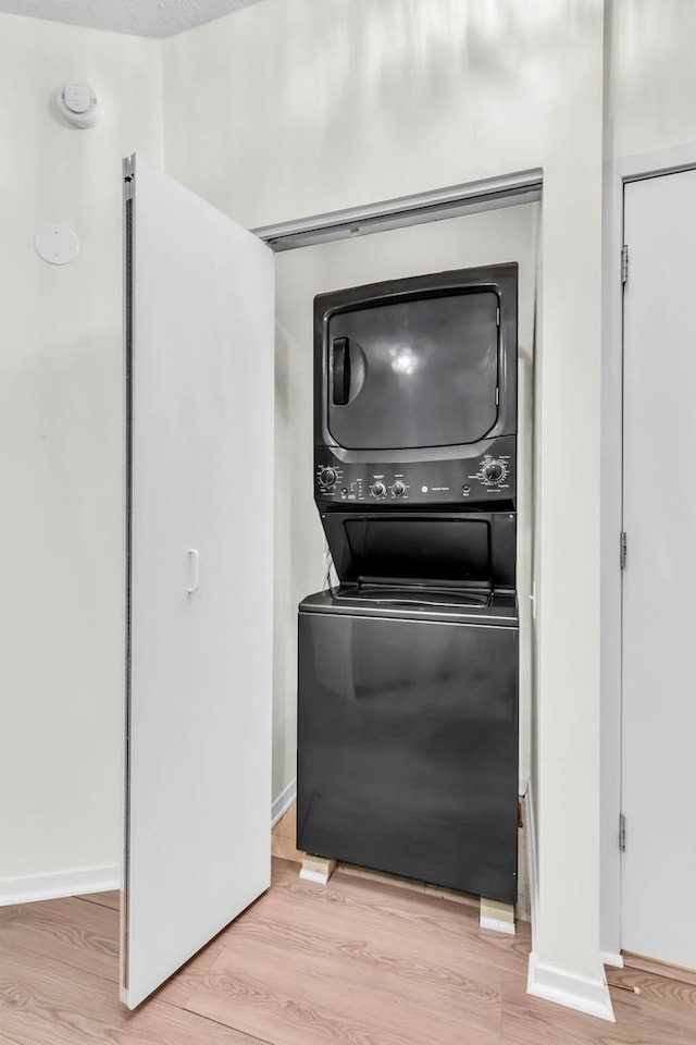 600 N Kingsbury St Unit 1114, Chicago, IL 60654 - laundry area featuring stacked washer / dryer, laundry area, baseboards, and wood finished floors