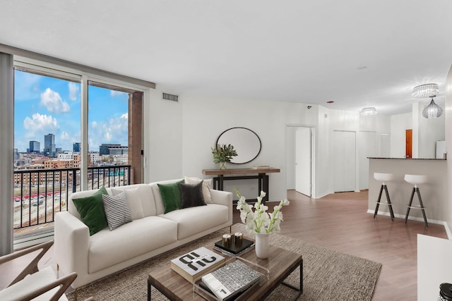 600 N Kingsbury St Unit 1114, Chicago, IL 60654 - living area with a wall of windows, visible vents, wood finished floors, a view of city, and baseboards