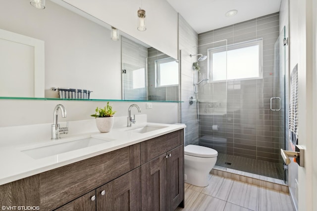 full bathroom featuring a sink, toilet, a shower stall, and double vanity