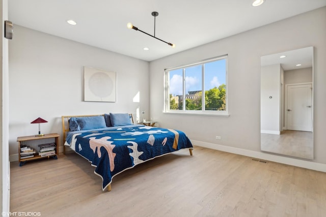 bedroom with recessed lighting, visible vents, baseboards, and wood finished floors