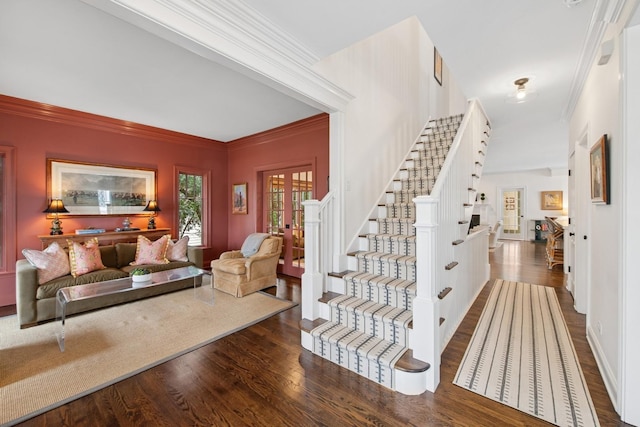 staircase with crown molding and wood finished floors