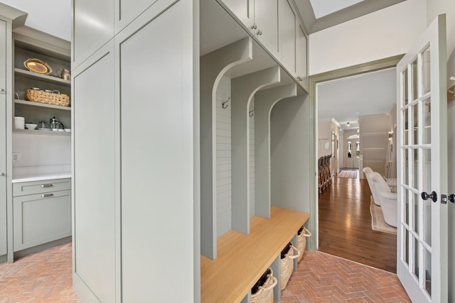 mudroom featuring french doors, brick floor, and arched walkways